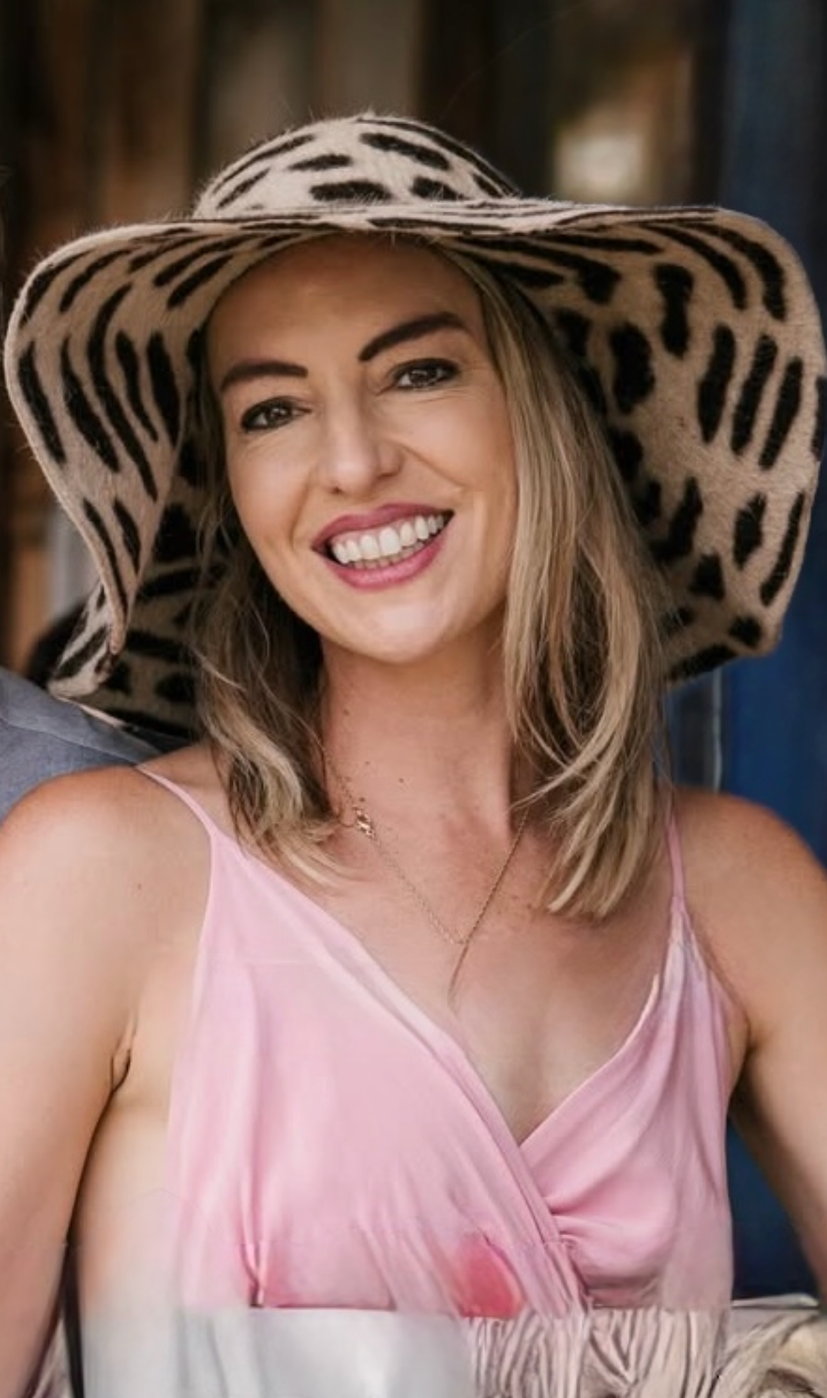 Elizabeth, founder of The You Reveal, smiling in a wide-brimmed hat and pink dress
